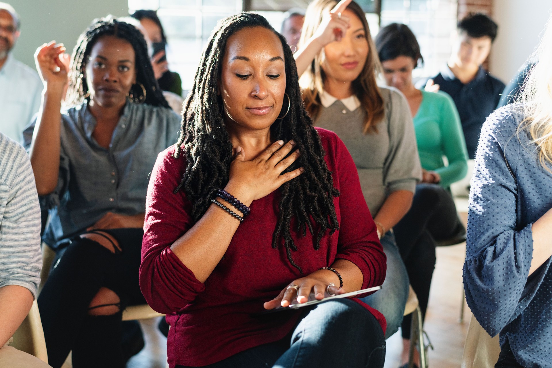 A diverse group of people in a workshop setting, focusing on mindfulness.